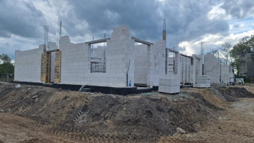 Widok na plac budowy z płytami betonowymi. Pierwsze piętro jest prawie gotowe.