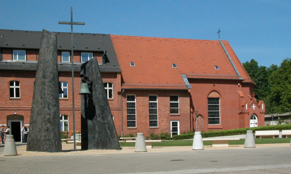 Przed kościołem z czerwonej cegły stoi dzwonnica Fundacji Stefana.